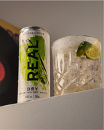 Alcohol-free 'REAL' dry can next to a glass with ice and lime.